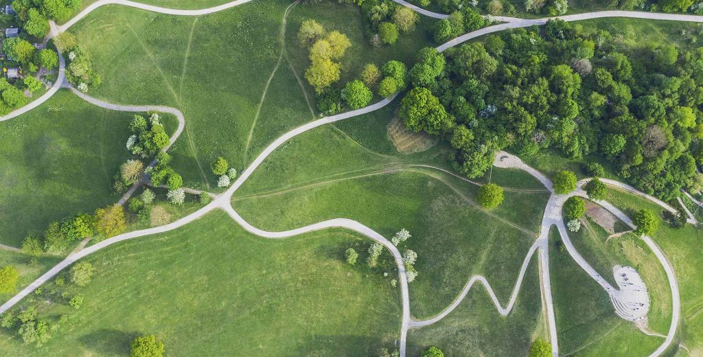 Luftaufnahme von einem Park mit grünem Gras und verschiedenen Wegen.